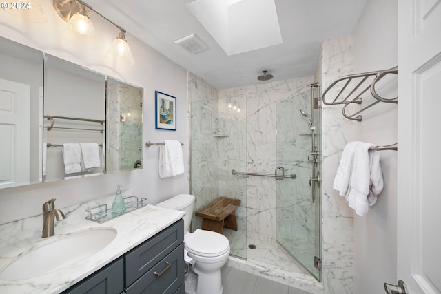 full bath with a marble finish shower, visible vents, toilet, a skylight, and vanity