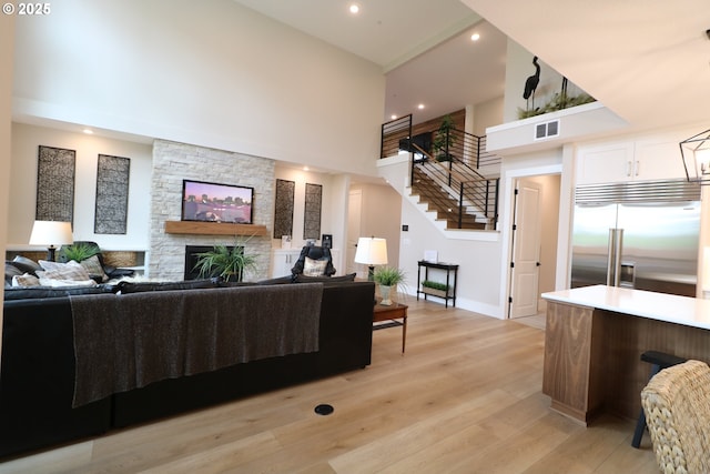 4908 NE 132nd Cir, Vancouver, WA 98686 - living area featuring a high ceiling, stairs, recessed lighting, a fireplace, and light wood-style floors