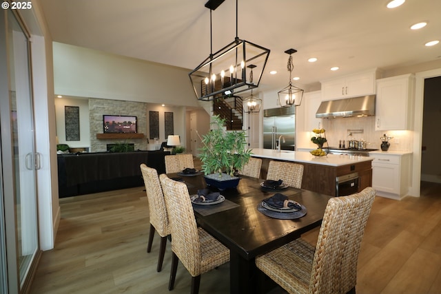 4908 NE 132nd Cir, Vancouver, WA 98686 - dining area featuring light wood-style flooring, recessed lighting, a chandelier, and a stone fireplace