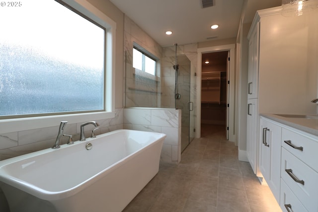 4908 NE 132nd Cir, Vancouver, WA 98686 - bathroom featuring a stall shower, a freestanding tub, a walk in closet, vanity, and tile patterned floors