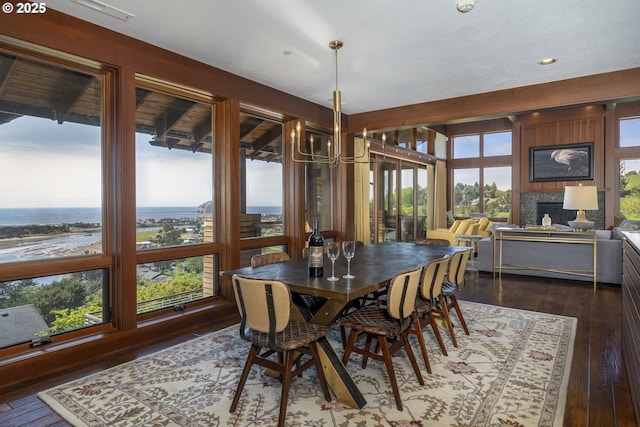 7850 Brooten Mountain Loop, Pacific City, OR 97135 - dining space featuring dark wood-style flooring, a chandelier, recessed lighting, and a fireplace