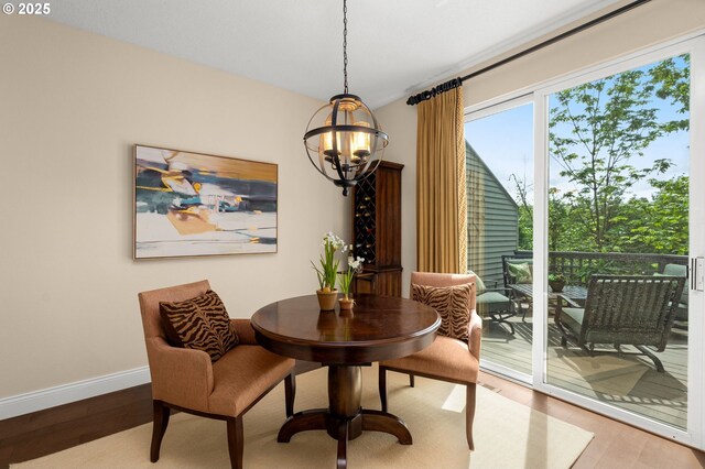 dining area with baseboards, a notable chandelier, and wood finished floors