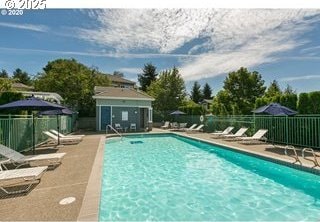 pool with a patio and fence