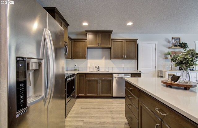 7407 NE 136th Ave, Vancouver, WA 98682 - kitchen with stainless steel appliances, light countertops, a textured ceiling, light wood finished floors, and recessed lighting