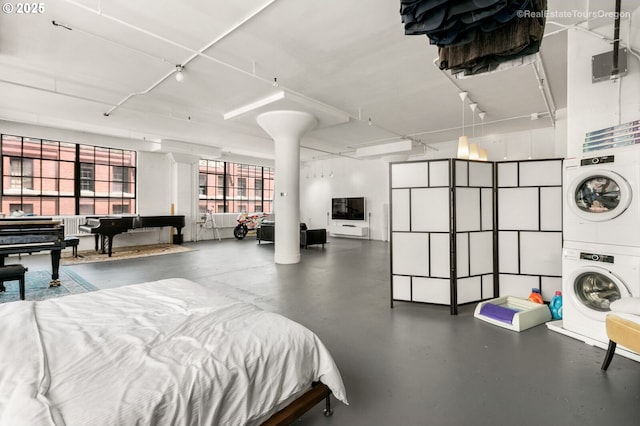 1314 NW Irving St Unit 510, Portland, OR 97209 - bedroom featuring stacked washer / drying machine and finished concrete flooring