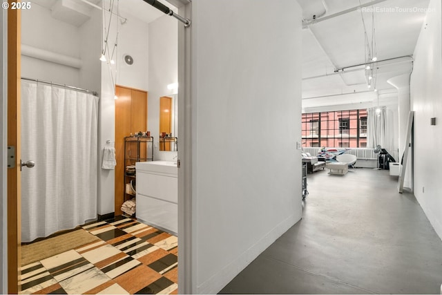 1314 NW Irving St Unit 510, Portland, OR 97209 - hall featuring baseboards, a towering ceiling, and finished concrete floors