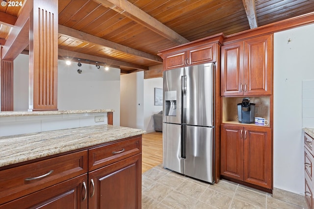 kitchen with beamed ceiling, stainless steel refrigerator with ice dispenser, wood ceiling, and light stone countertops