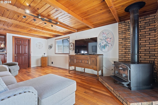 1833 SE 117th Ave, Portland, OR 97216 - living area with wainscoting, a wood stove, wood finished floors, wooden ceiling, and beamed ceiling
