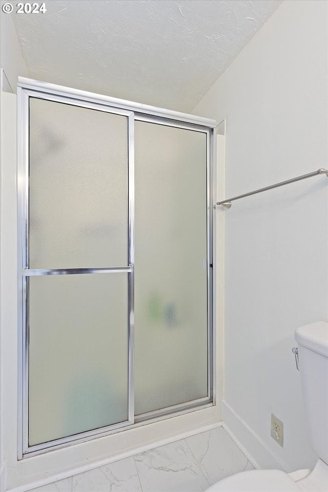 1833 SE 117th Ave, Portland, OR 97216 - full bathroom featuring a shower with shower door, toilet, and marble finish floor