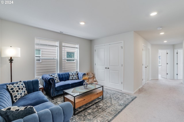 living area featuring baseboards, recessed lighting, and light carpet