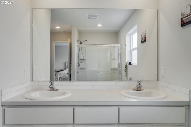 bathroom with ensuite bathroom, visible vents, a sink, and a stall shower