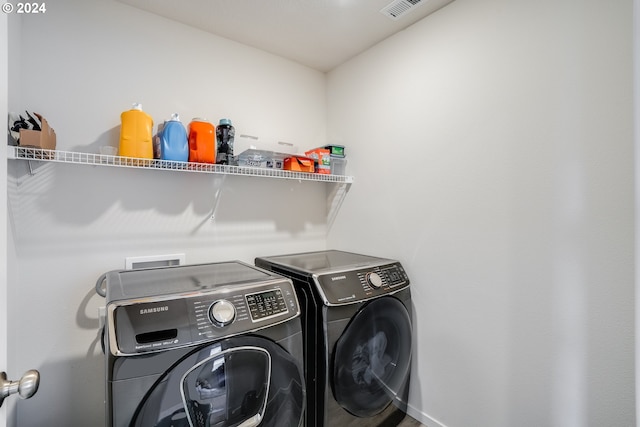 laundry room with washer and dryer, visible vents, and laundry area