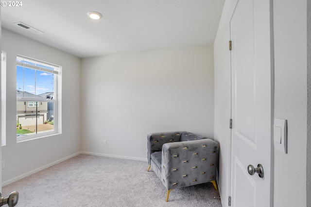 living area with visible vents, baseboards, and carpet flooring