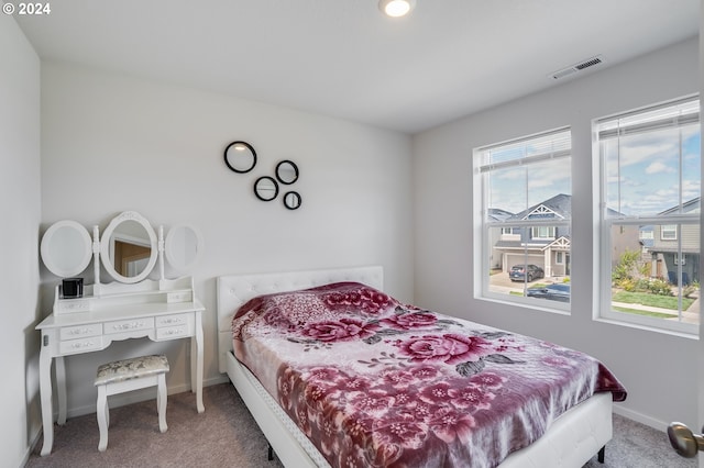 bedroom featuring visible vents, baseboards, and carpet