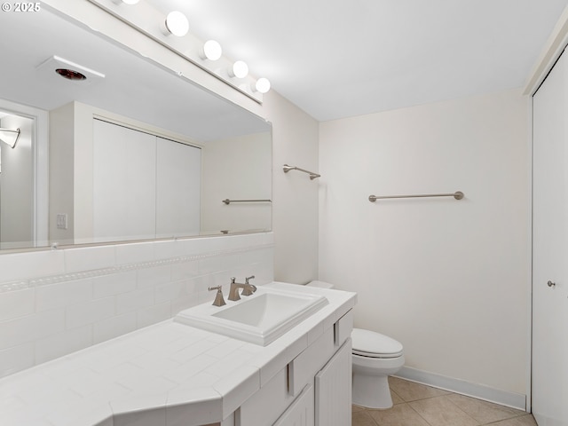 bathroom featuring vanity, toilet, tile patterned flooring, and decorative backsplash