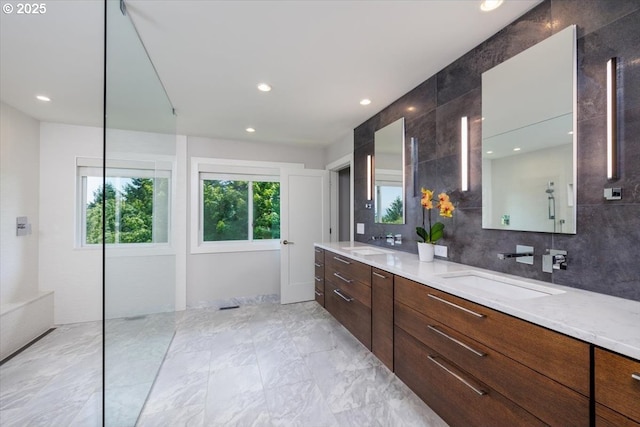 bathroom with a sink, recessed lighting, double vanity, and tasteful backsplash