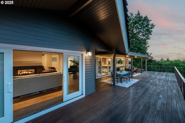 deck at dusk featuring outdoor dining area