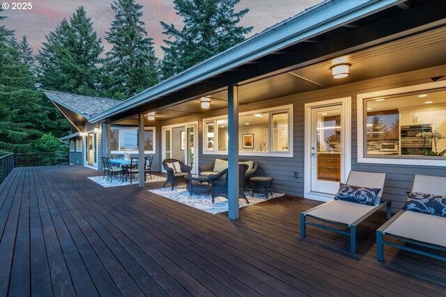 deck at dusk featuring outdoor dining space
