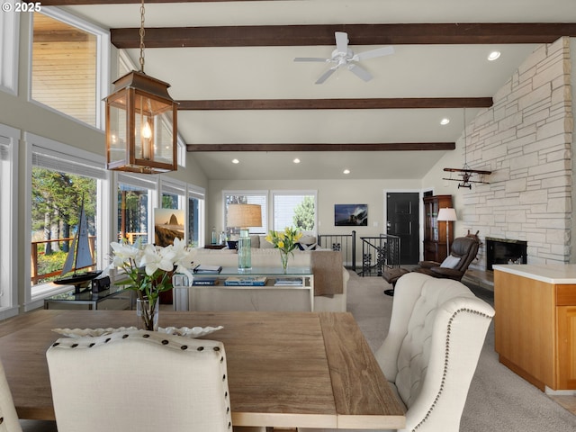 dining room with beamed ceiling, a fireplace, high vaulted ceiling, and ceiling fan