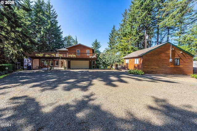 2165 NE E Devils Lake Rd, Otis, OR 97368 - view of front facade featuring a deck, gravel driveway, and a garage