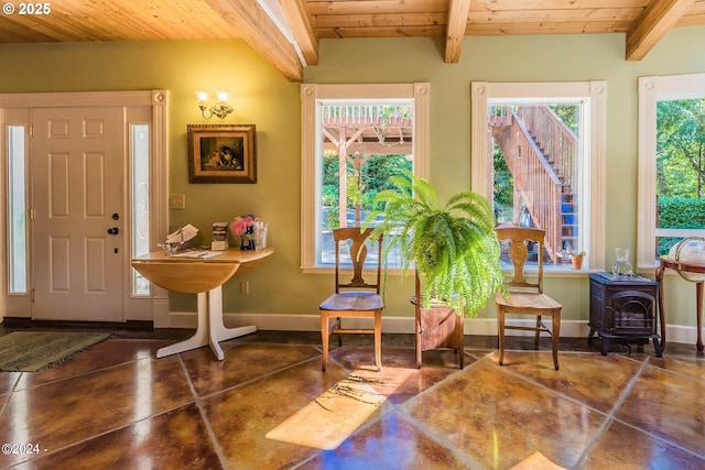 2165 NE E Devils Lake Rd, Otis, OR 97368 - entrance foyer with wood ceiling with exposed beams, concrete flooring, a wood stove, and baseboards