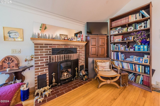 2165 NE E Devils Lake Rd, Otis, OR 97368 - living area featuring ornamental molding, a fireplace, lofted ceiling, and wood finished floors