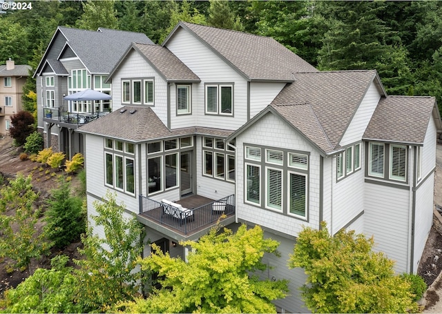 3232 NW Spencer St, Portland, OR 97229 - rear view of house featuring roof with shingles, a sunroom, and a deck