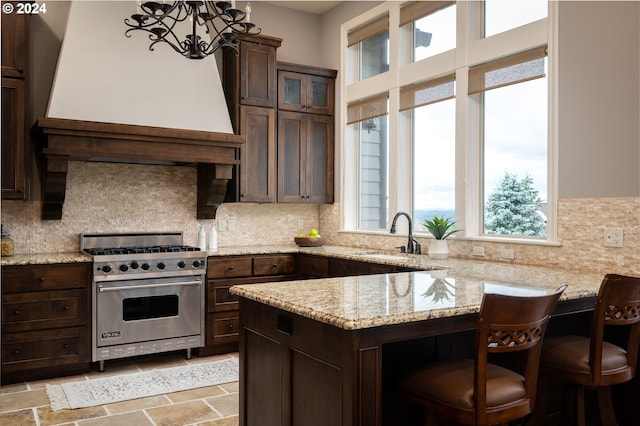 3232 NW Spencer St, Portland, OR 97229 - kitchen with designer range, dark brown cabinets, a chandelier, a peninsula, and backsplash