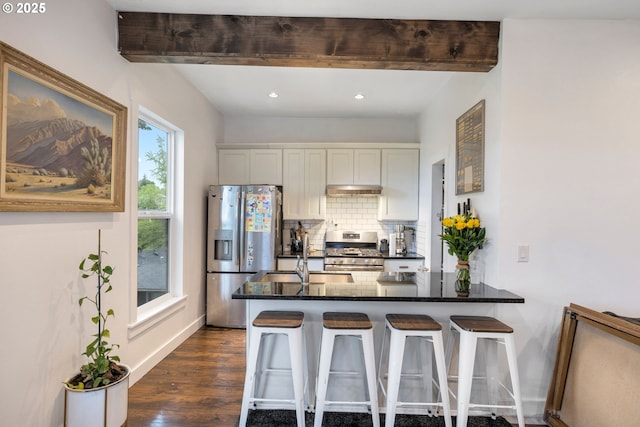 709 10th St, Oregon City, OR 97045 - kitchen with stainless steel appliances, decorative backsplash, a sink, dark wood-style flooring, and a breakfast bar area
