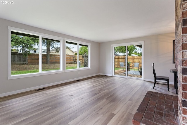 unfurnished living room with wood finished floors and baseboards