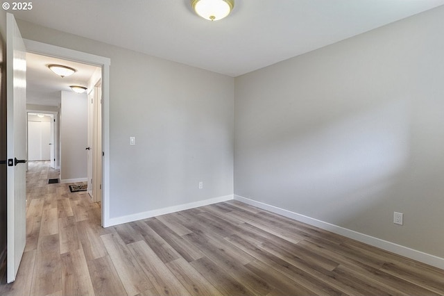 empty room with wood finished floors and baseboards