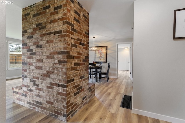 corridor featuring baseboards and light wood-style floors