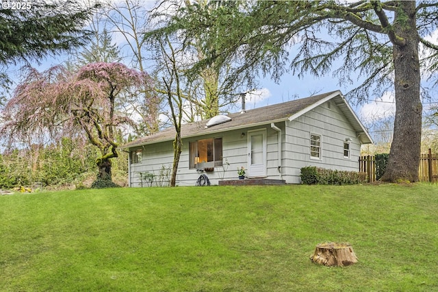 view of front of property featuring a front lawn and fence