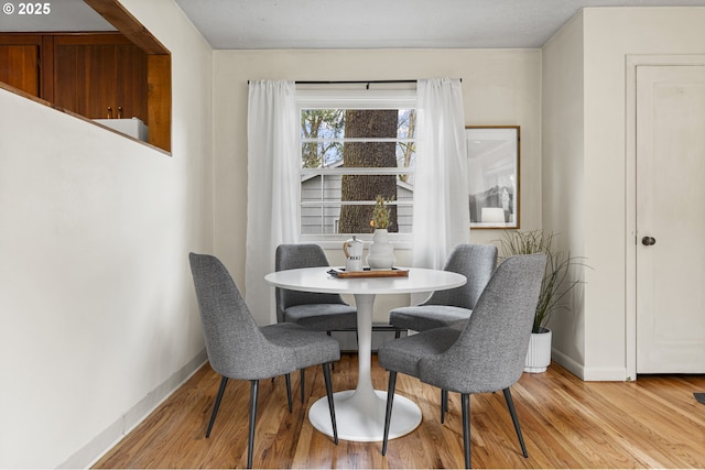 dining area with light wood-style floors and baseboards