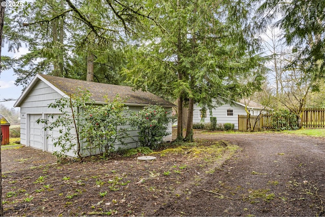 view of front of home featuring an outbuilding, fence, and a detached garage