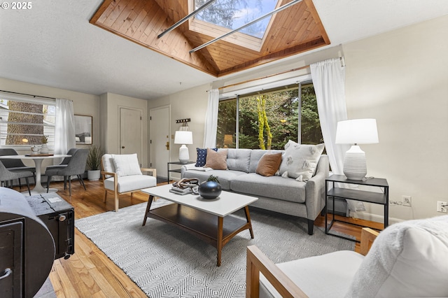 living room featuring light wood-type flooring, a skylight, and a baseboard radiator