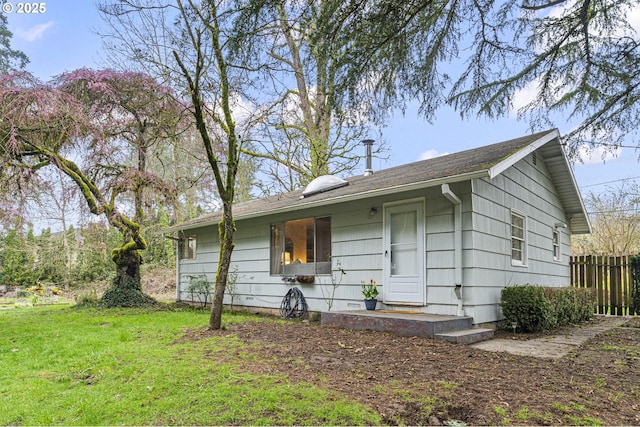 single story home featuring a front lawn and fence