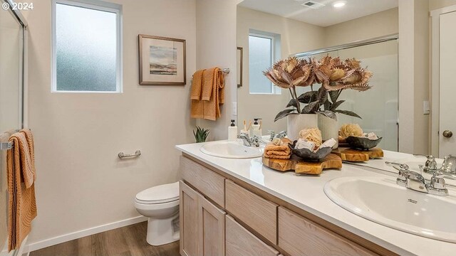6138 SE 15th St, Gresham, OR 97080 - bathroom featuring a shower with door, toilet, double vanity, wood finished floors, and baseboards