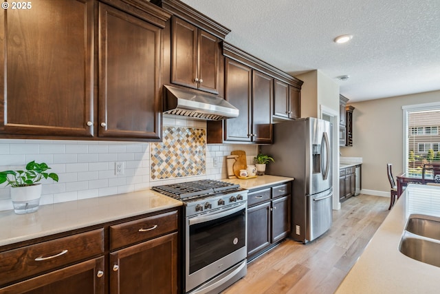 4905 S 12th Cir, Ridgefield, WA 98642 - kitchen with appliances with stainless steel finishes, under cabinet range hood, light wood-style floors, light countertops, and a textured ceiling