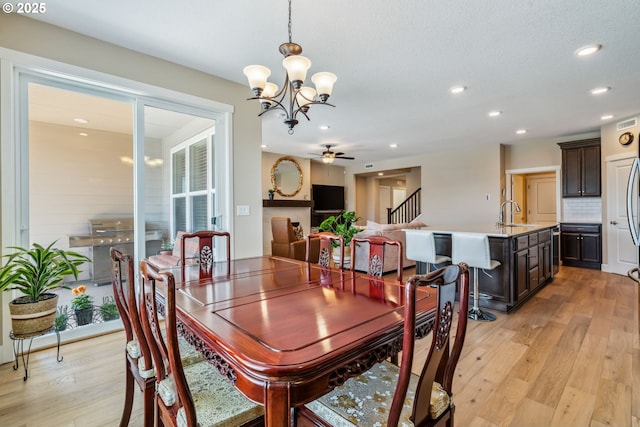 4905 S 12th Cir, Ridgefield, WA 98642 - dining room featuring a chandelier, light wood finished floors, recessed lighting, ceiling fan, and stairs