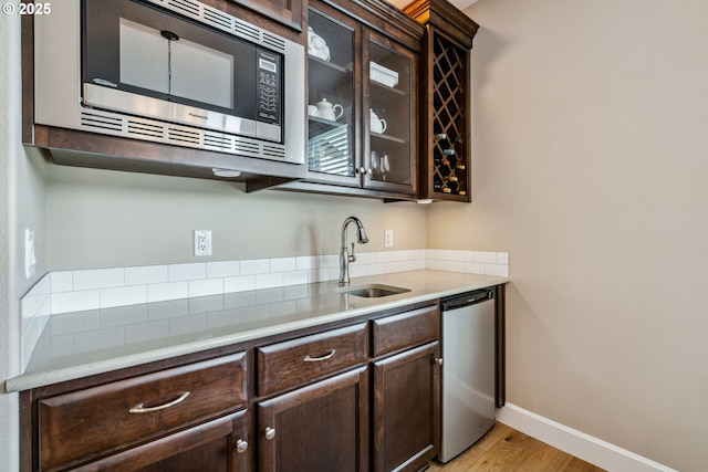 4905 S 12th Cir, Ridgefield, WA 98642 - kitchen with stainless steel appliances, dark brown cabinets, light wood-style floors, glass insert cabinets, and light countertops