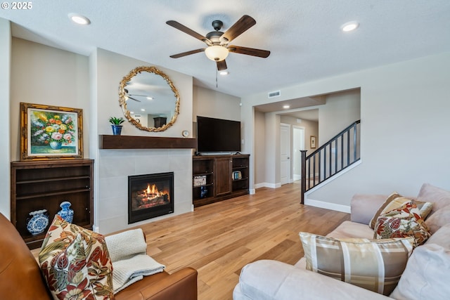 4905 S 12th Cir, Ridgefield, WA 98642 - living room with a ceiling fan, wood finished floors, stairway, a tiled fireplace, and recessed lighting