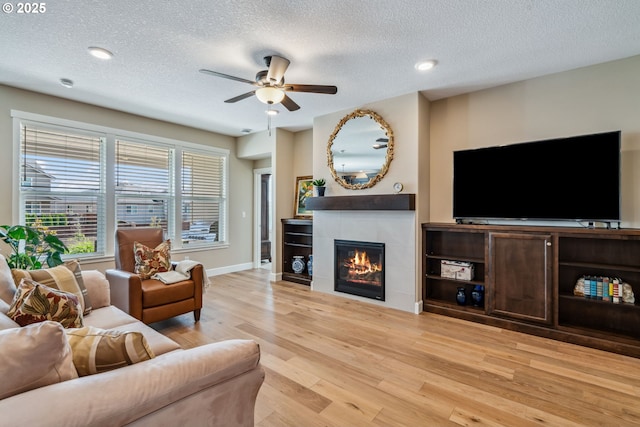 4905 S 12th Cir, Ridgefield, WA 98642 - living room featuring ceiling fan, light wood-type flooring, a textured ceiling, a tile fireplace, and recessed lighting