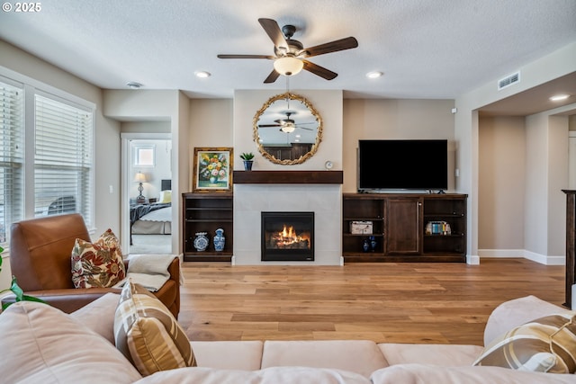 4905 S 12th Cir, Ridgefield, WA 98642 - living room with a ceiling fan, wood finished floors, a tile fireplace, a textured ceiling, and recessed lighting