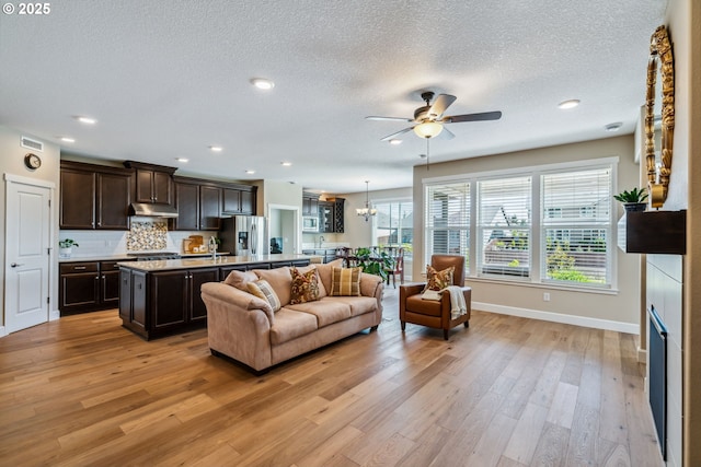 4905 S 12th Cir, Ridgefield, WA 98642 - living room with light wood-style floors, a ceiling fan, a textured ceiling, recessed lighting, and a chandelier