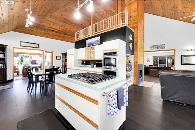 kitchen featuring track lighting, wooden ceiling, appliances with stainless steel finishes, high vaulted ceiling, and white cabinets