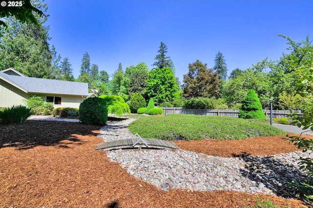 view of yard featuring fence and view of scattered trees