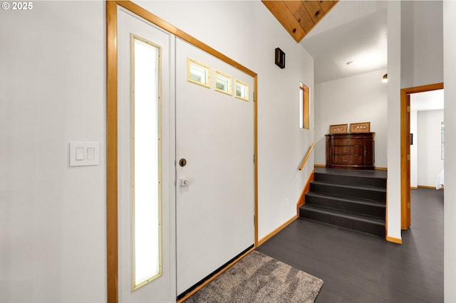 foyer with lofted ceiling, stairway, and baseboards