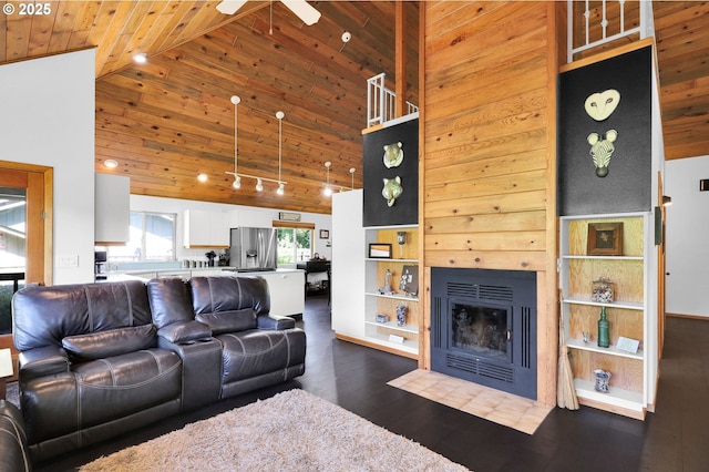 living room featuring wood ceiling, a fireplace with flush hearth, dark wood-type flooring, a ceiling fan, and high vaulted ceiling