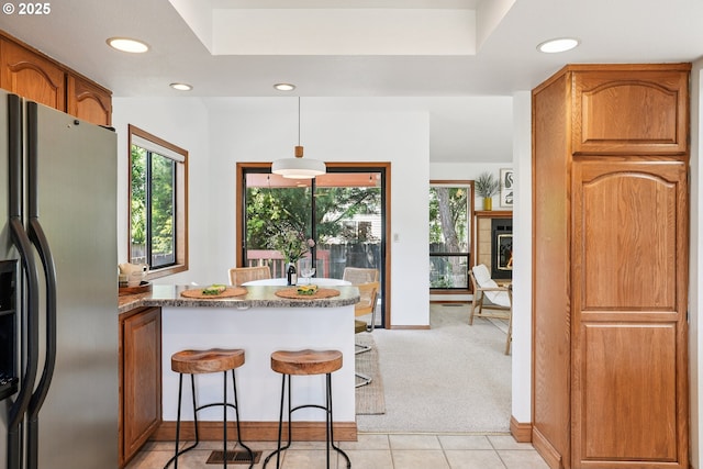 2027 SE Lexington St, Portland, OR 97202 - kitchen with fridge with ice dispenser, plenty of natural light, recessed lighting, a peninsula, and brown cabinets
